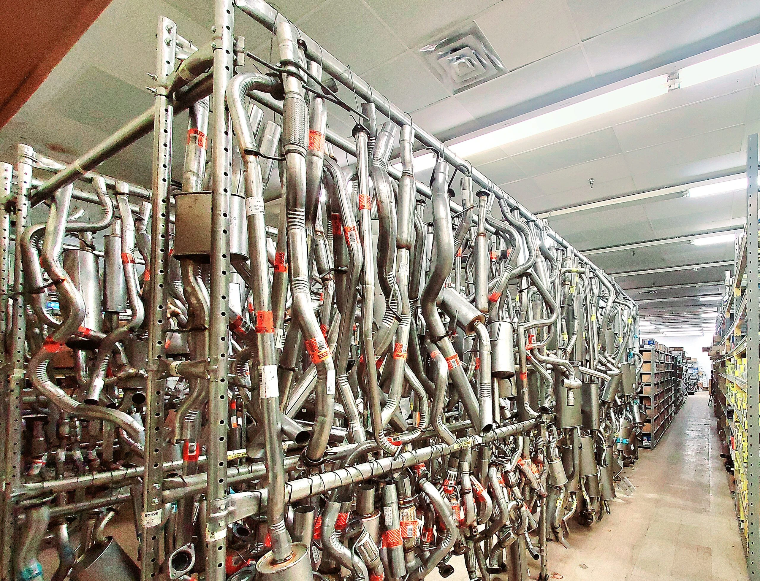 Rows of racks containing exhausts that are stocked at United Auto Supply in Burnt Hills.
