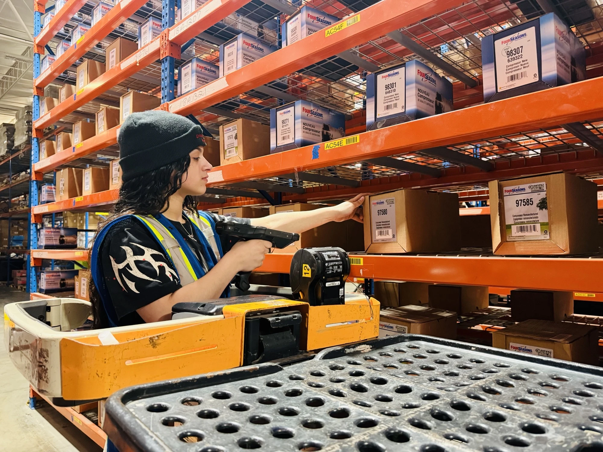 Employee scanning inventory of auto parts.